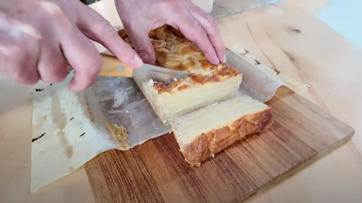 Christopher Kimball slicing into the Invisible Apple Cake from Milk Street