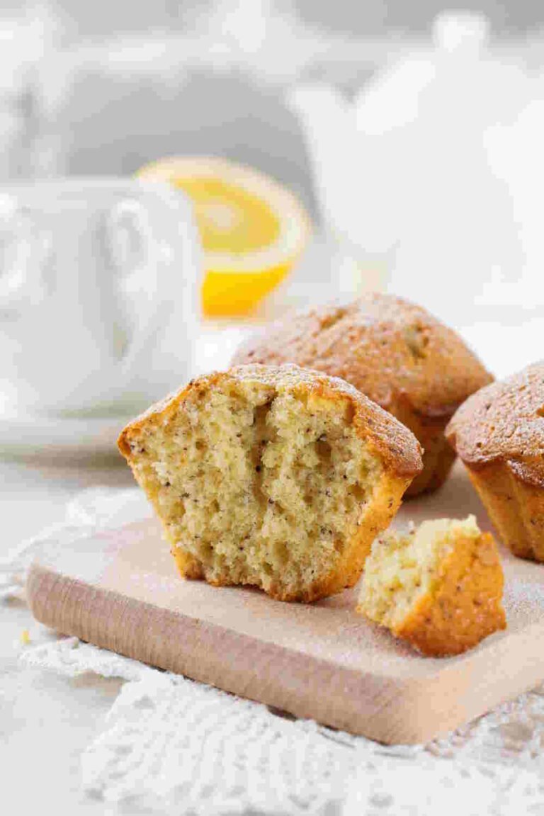 Keto Lemon Poppy Seed Muffins with poppy seeds on a wooden stand on a light background.