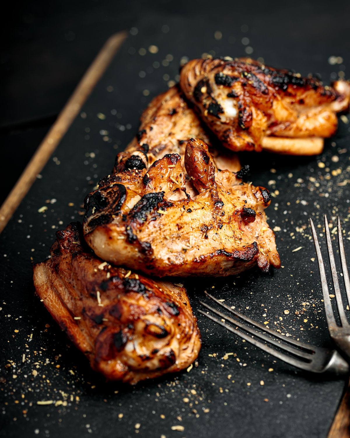 Succulent grilled chicken thighs on slate