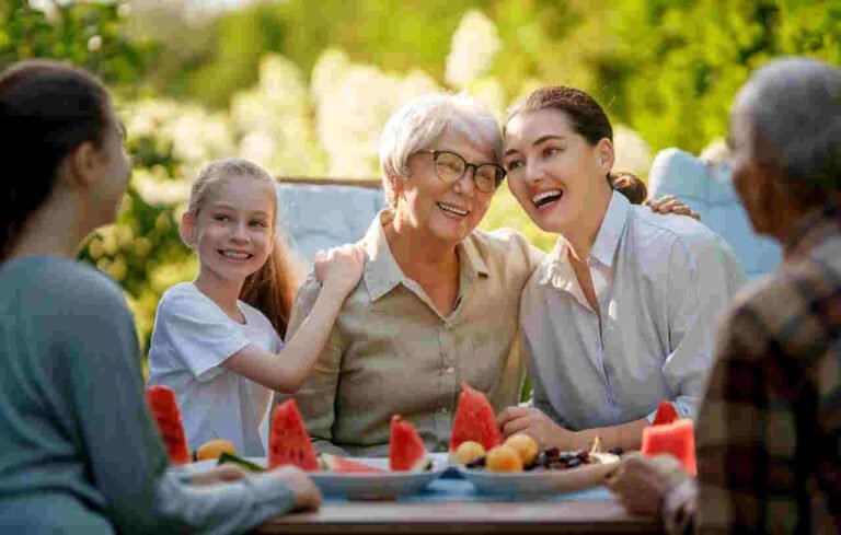Lunch with Grandparents spending time together in summer morning. Family sitting in the garden and enjoying the conversation.