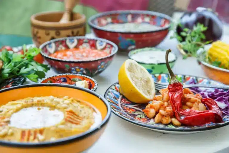 Mediterranean diet lunch with traditional meze: hummus, babaganoush, harissa, tzatziki on white background