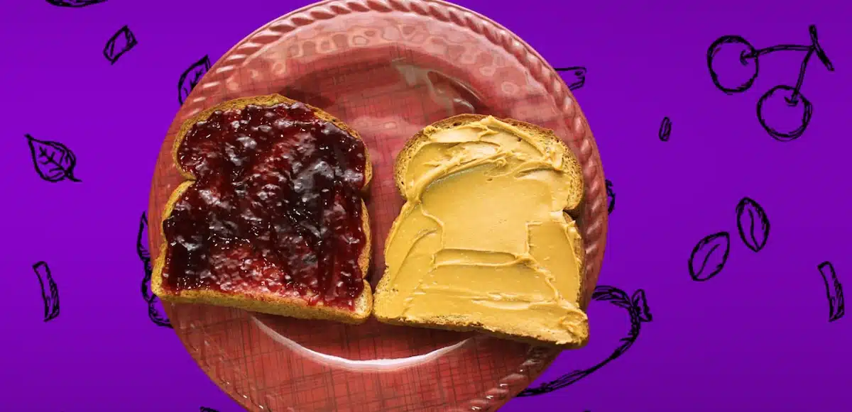 A Nutritious PB&J Makeover with jelly on a slice of bread and cashew butter on the other both on a plate prior to be combined into a sandwich