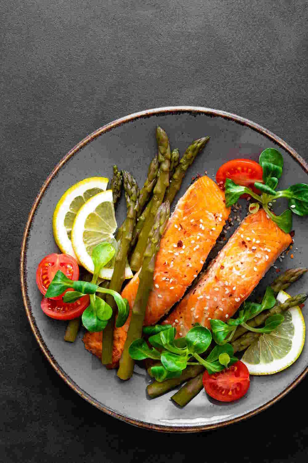 Sheet Pan Salmon with Asparagus,tomato and corn salad on plate.