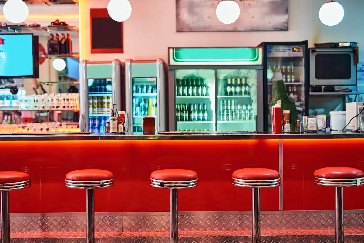 Photo of a red lunch counter with red stools and a glass refrigerated counmter in the rear Remembering the lunch counter is an integral part of our collective nostalgia