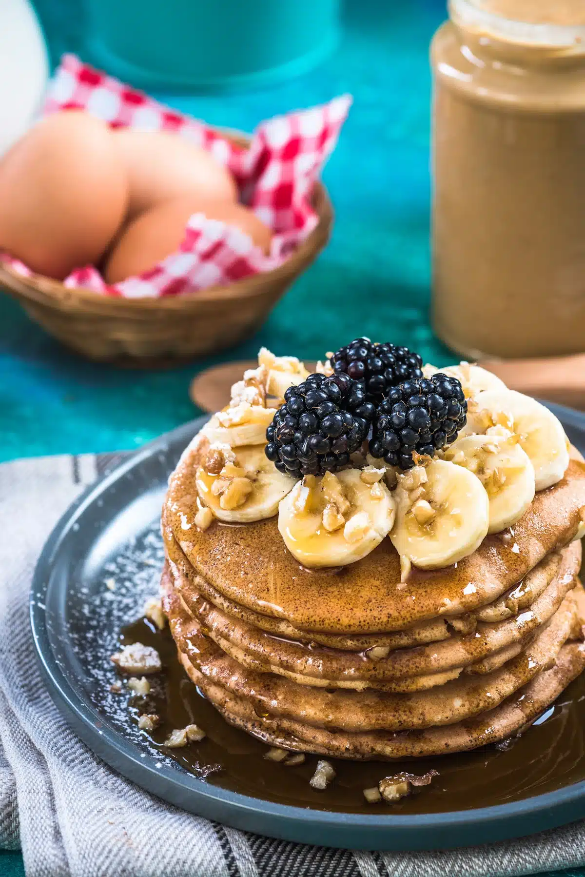 Whole Wheat pancakes with blackberries walnuts banana and maple syrup