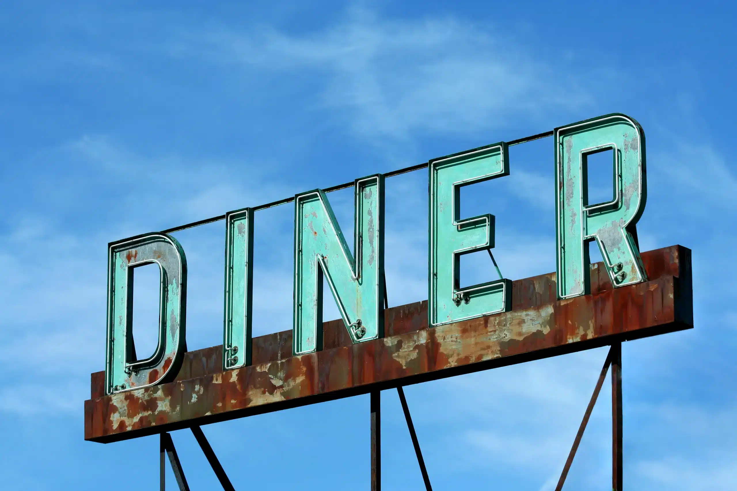 A sign on the roof of an old diner