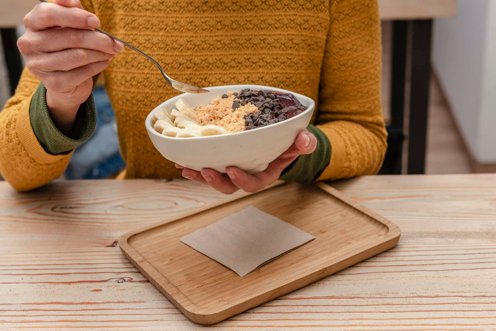 an unrecognizable woman eating acai bowl