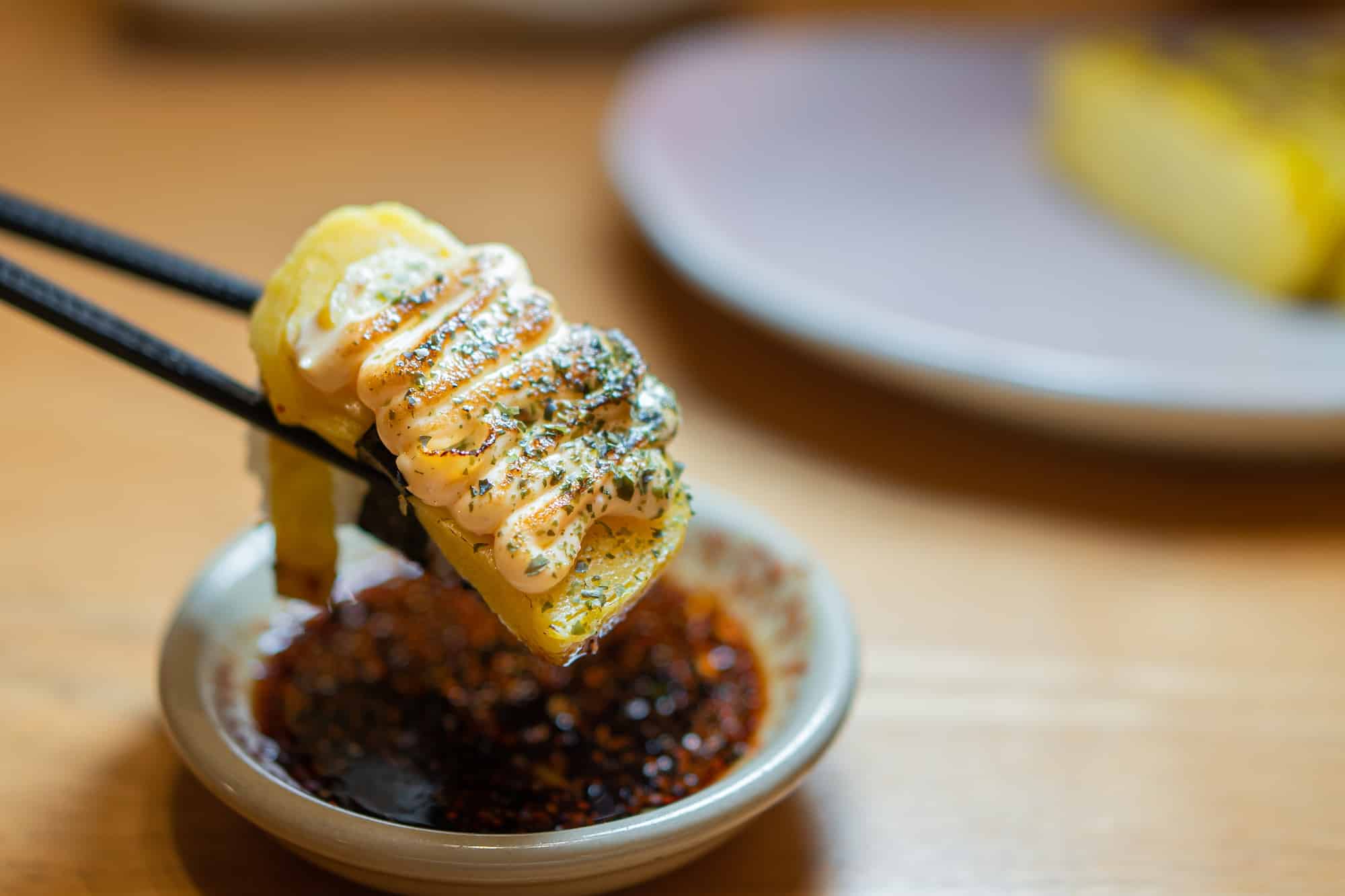 close up of sushi with chopsticks and soy