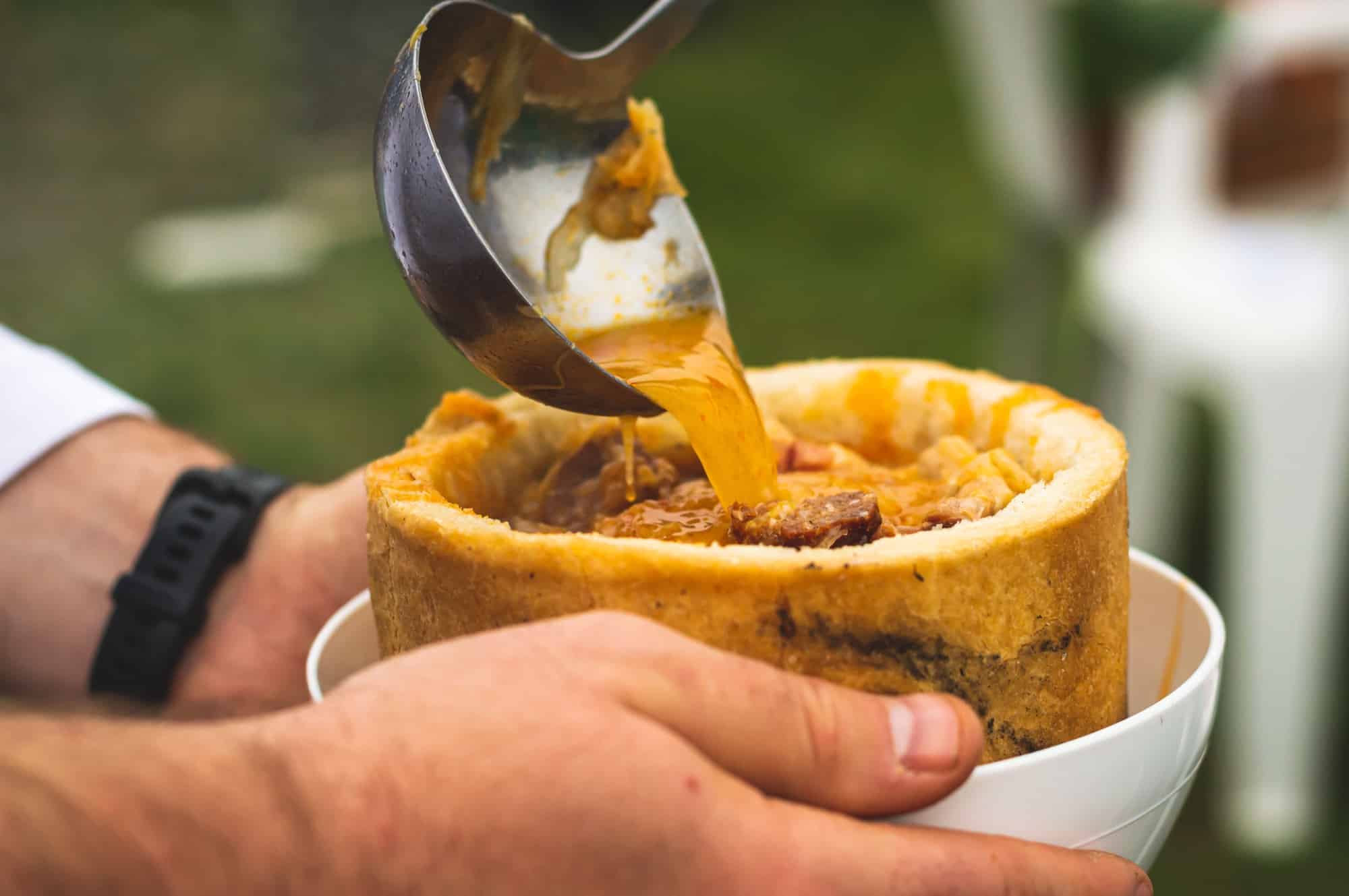 Closeup of a delicious dish with bread filling the yellow sauce in it with pieces of meat