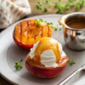 Grilled peaches with ice cream and caramel sauce, summer dessert