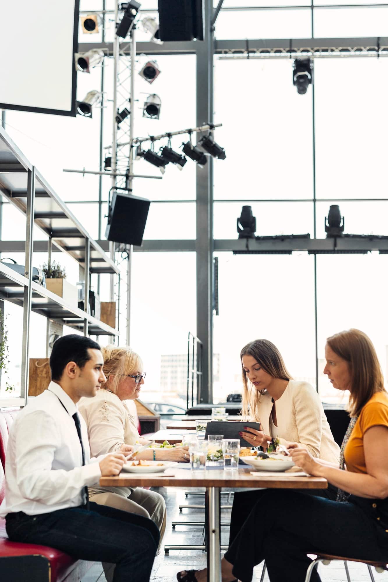 Group of colleagues enjoying a meal together in a modern restaurant