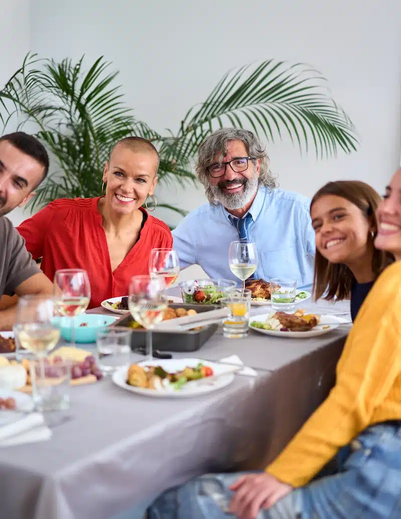 cheerful family posing with big smiles over lunch