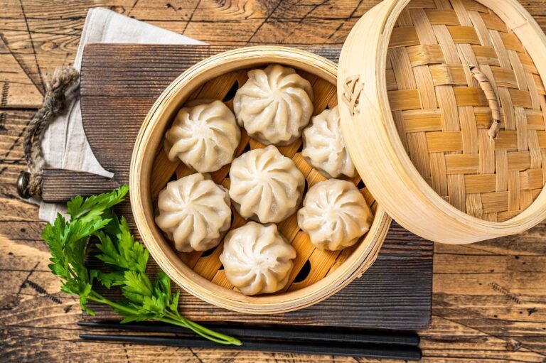 Dumplings in a bamboo steamer. Wooden background. Top view are among the excellent Heart-Healthy Chinese Lunch Selections