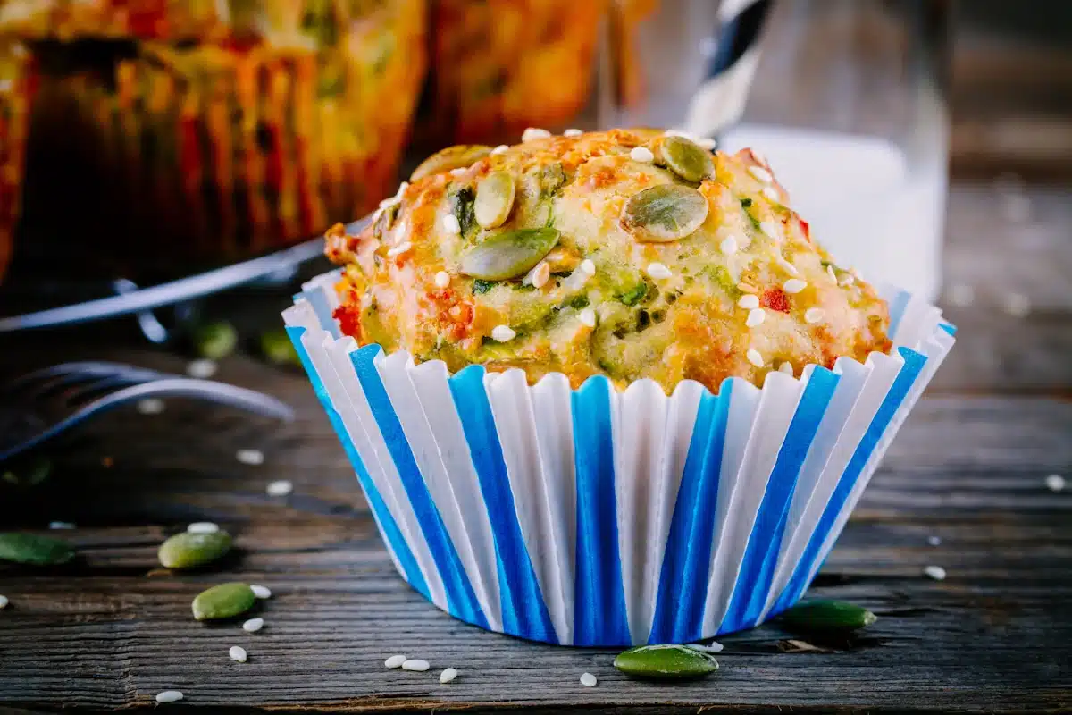 A muffin with spinach, feta cheese, pumpkin seeds and sesame seeds.