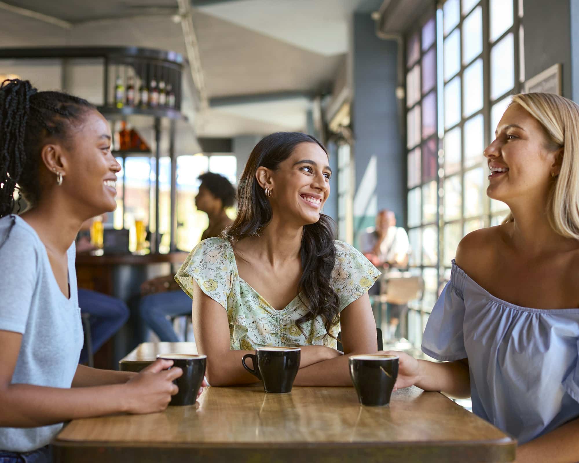 Multi-Cultural Group Of Female Friends Meeting former colleagues In a Restaurant Or Coffee Shop