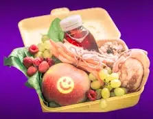 photo of a lunchbox filled with fruit and bread abnd juice grains and vegetables