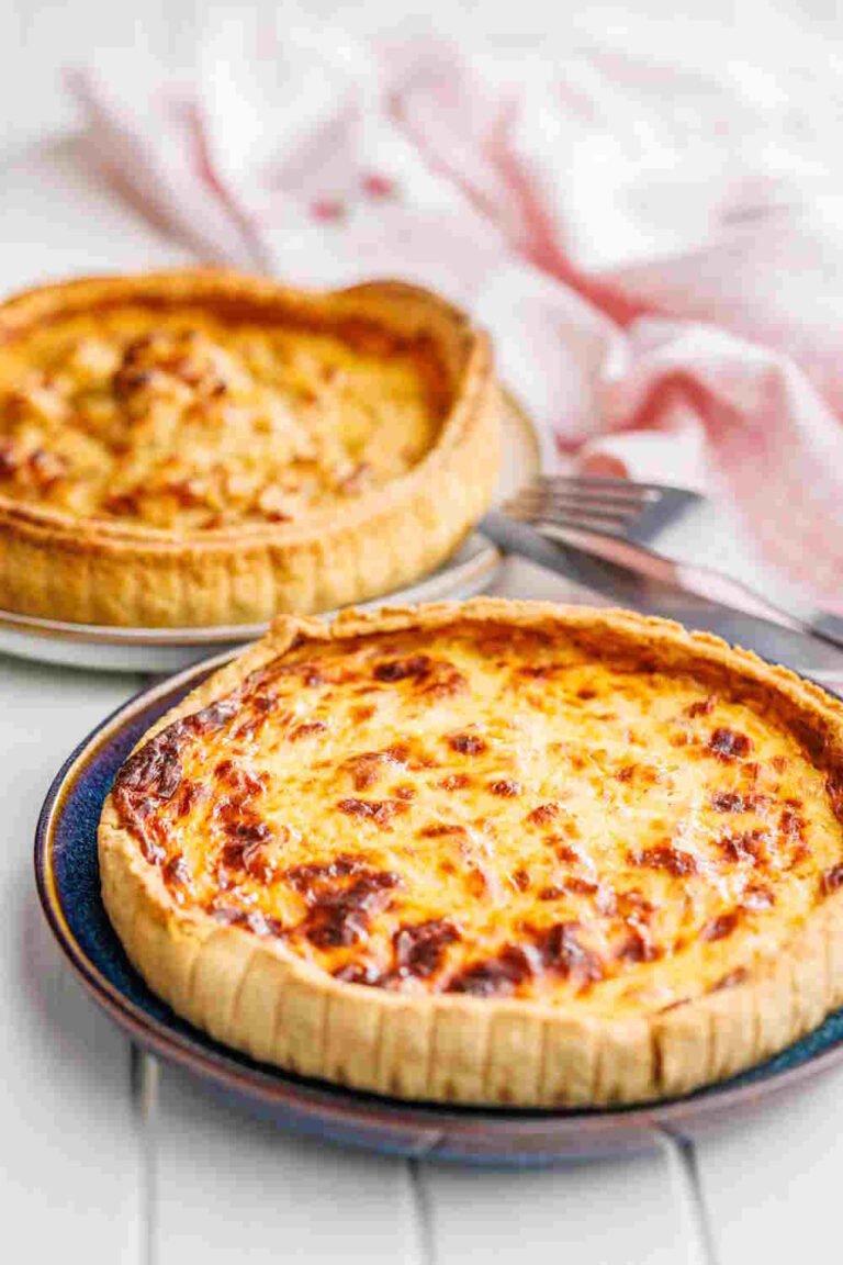Two baked quiche lorraines on plates