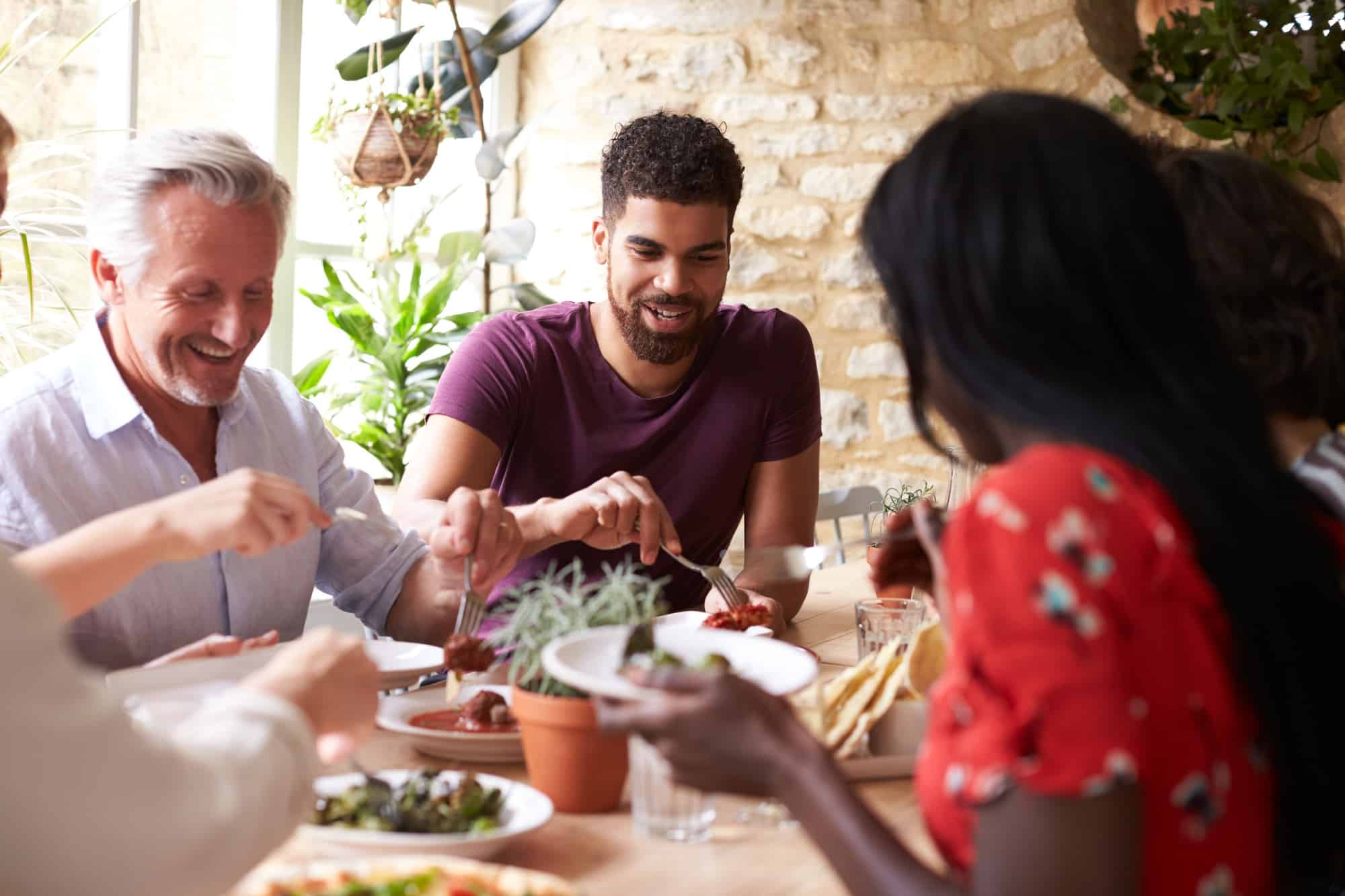 Smiling friends eating together at a table in a cafe