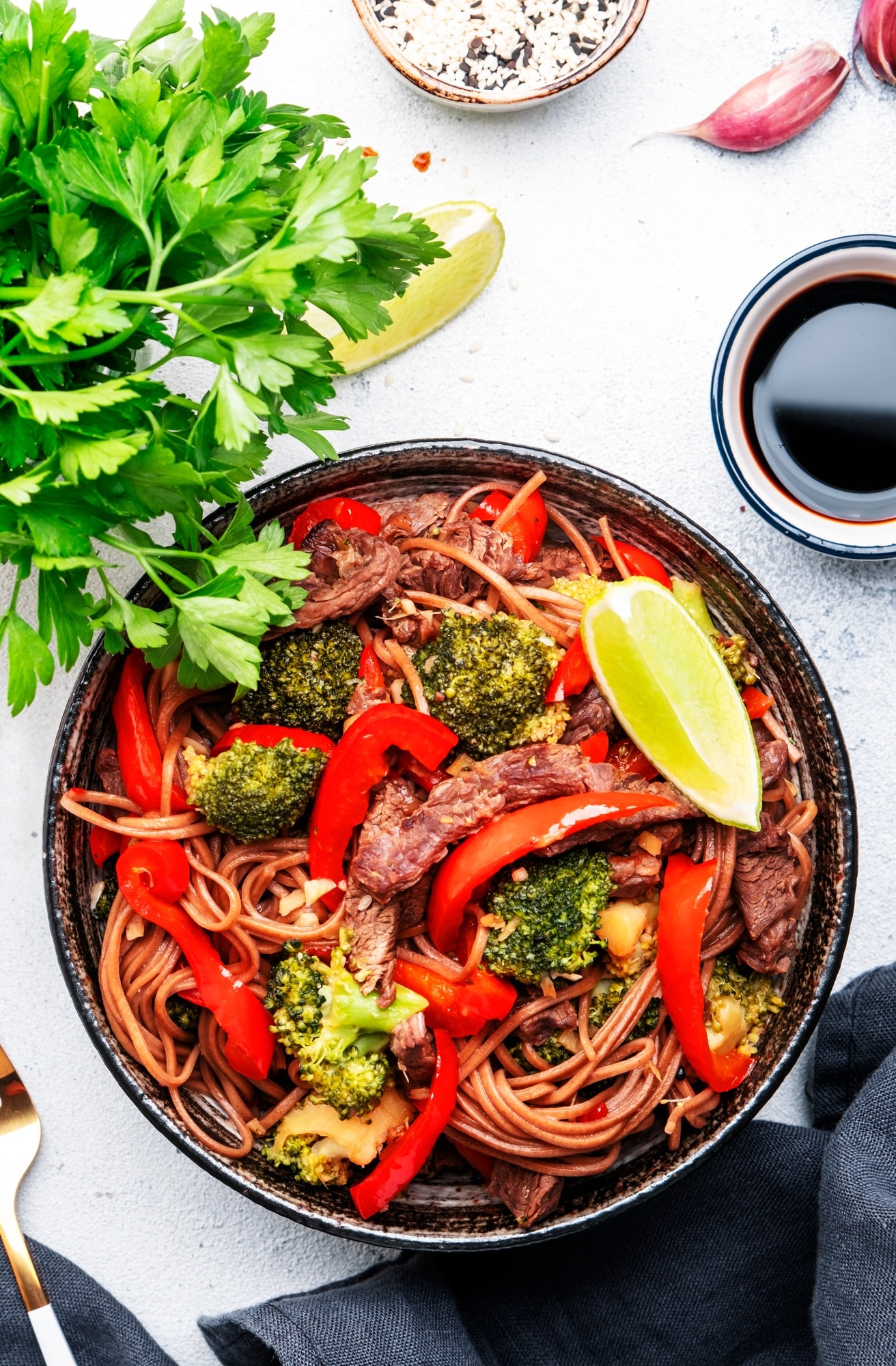 Stir fry noodles with vegetables and beef, paprika and broccoli with sesame seeds