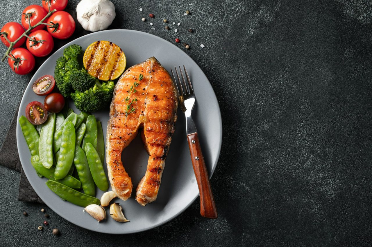 tasty-and-healthy-salmon-steak-with-green-peas-broccoli-and-tomatoes-on-a-gray-plate-.jpg