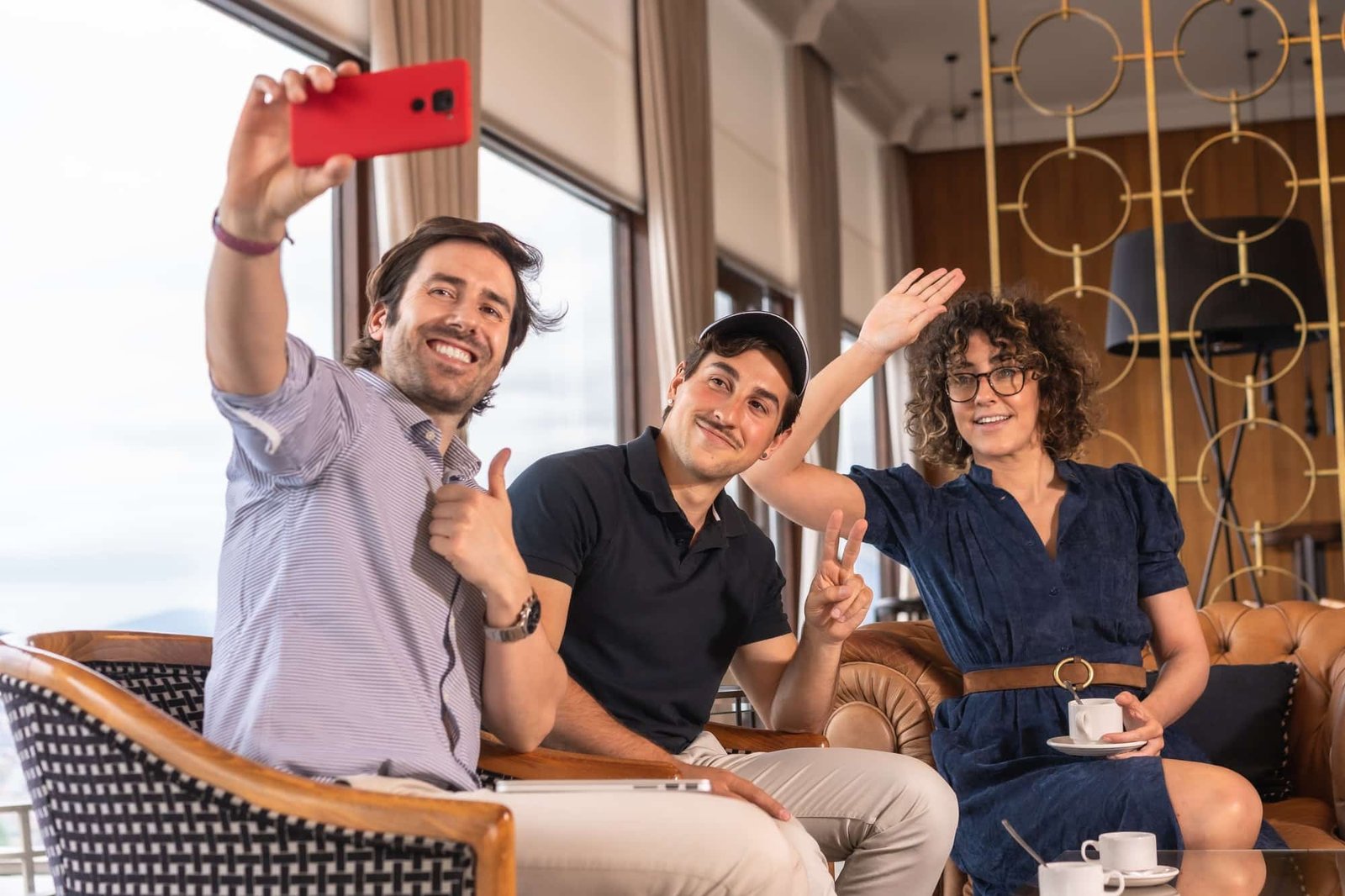 Team work with two men and a woman gesturing while taking a selfie