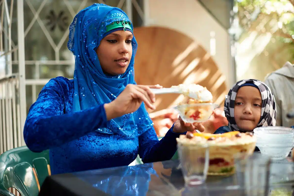 A woman scooping out desert for her daughter