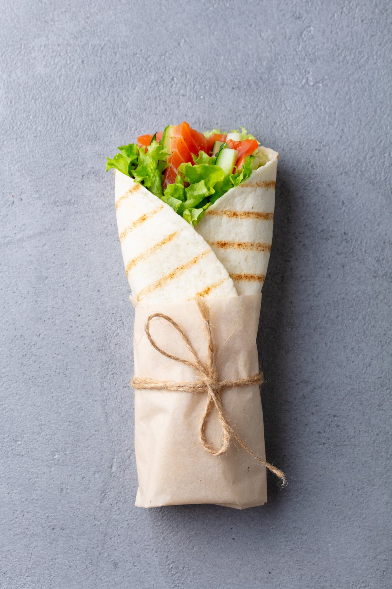 Wrap Sandwich, Roll with Fish Salmon and Vegetables. Grey Background. Top View.